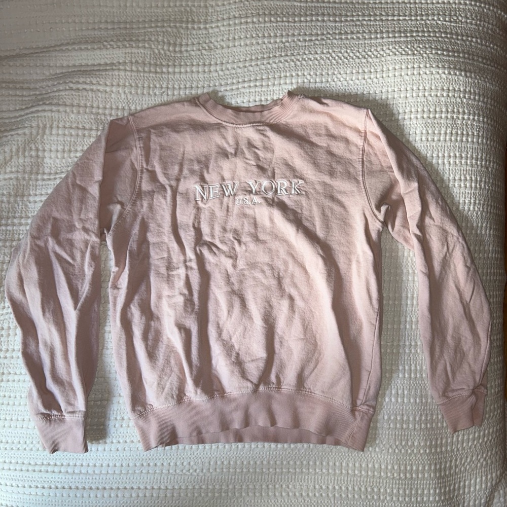 Light pink crewneck from Brandy Melville. Says: NEW YORK U.S.A.